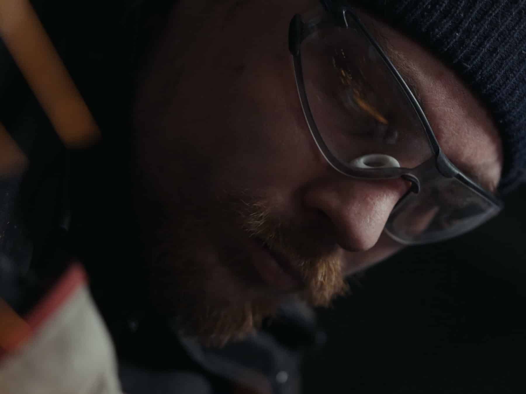Loïc Caboussat, serrurier-constructeur, lunettes de protection et bonnet, à la meuleuse dans l'atelier